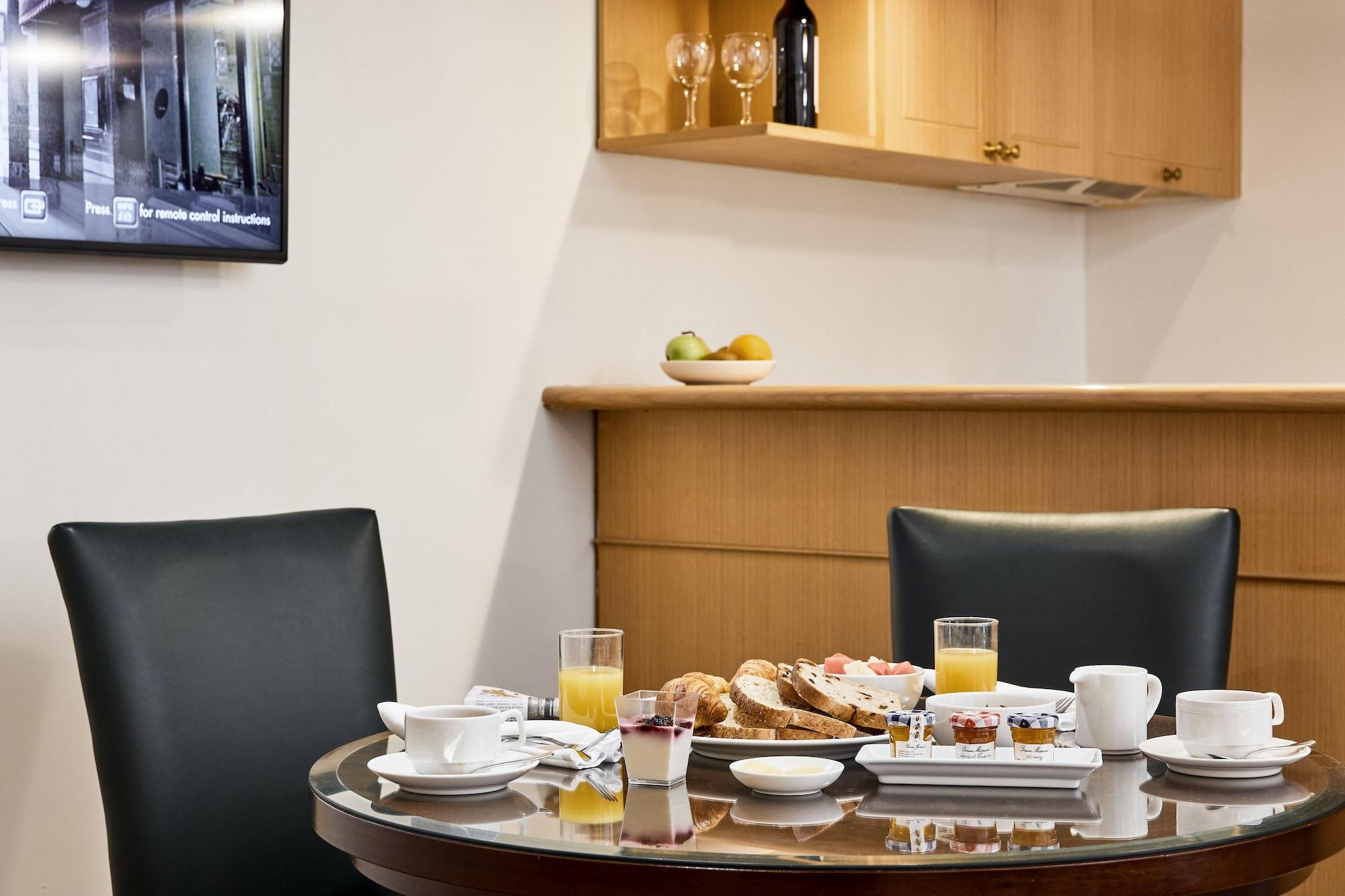Hotel Stamford Plaza Melbourne Esterno foto The photo shows a dining table set for breakfast or brunch. There are several food items displayed, including pastries and bread. Additionally, there are drinks, such as orange juice, served in glasses, and coffee in white cups. The table is round an