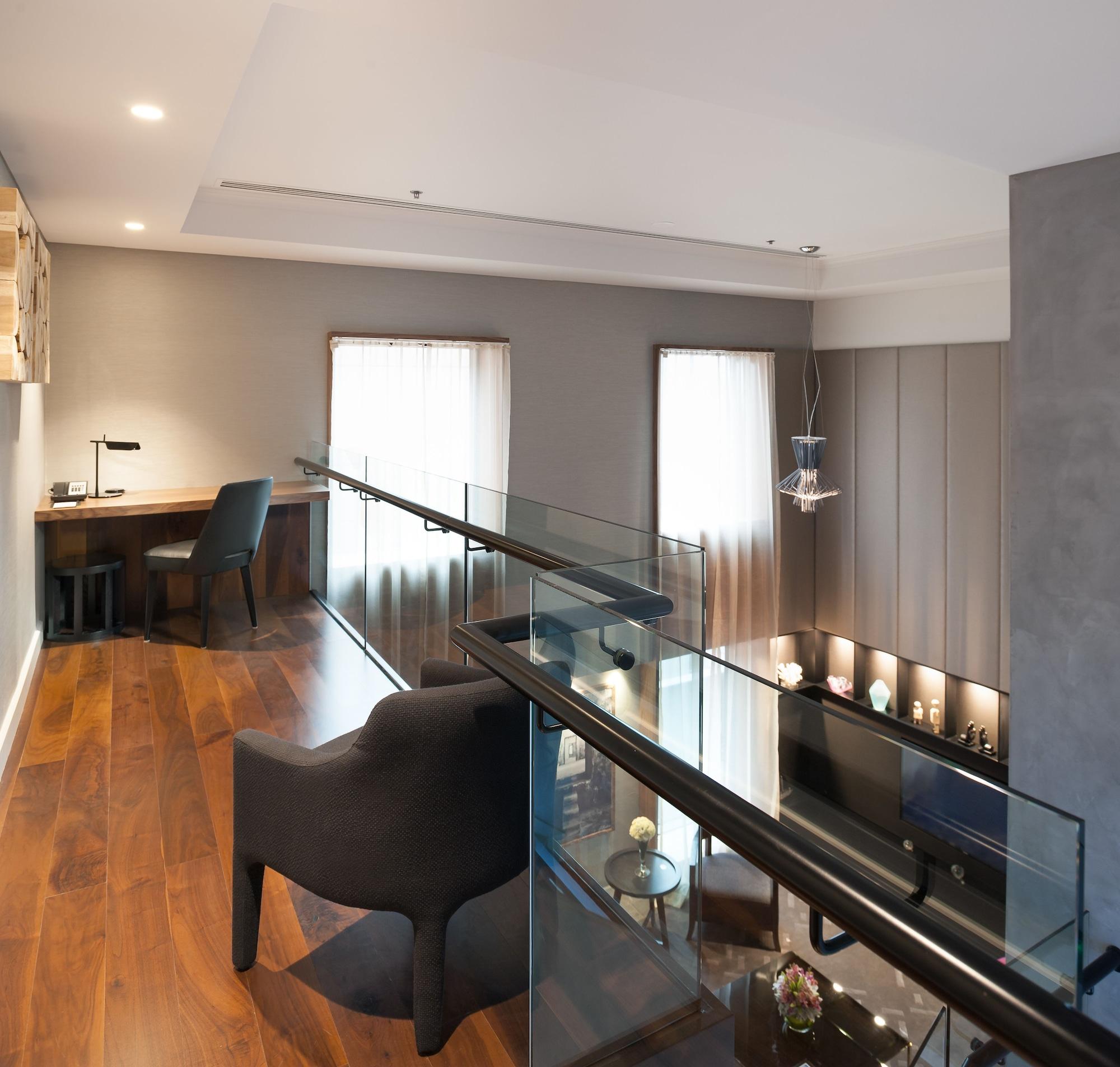 Hotel Stamford Plaza Melbourne Esterno foto The photo shows a modern interior space, featuring a second-floor balcony overlooking a lower level. The decor is stylish and minimalistic, with a combination of wooden flooring and neutral-colored walls. 

On the upper level, there is a small desk a