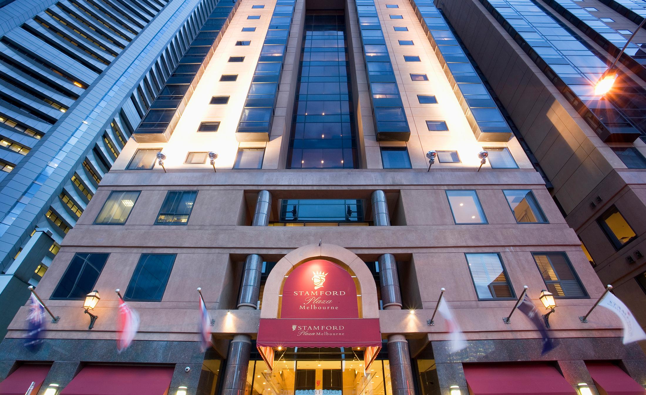 Hotel Stamford Plaza Melbourne Esterno foto The photo shows the entrance of a modern hotel building. The architecture features a tall structure with glass and stone elements. The hotel's name is visible above the entrance, which is framed by an arch, and the facade includes multiple levels wit