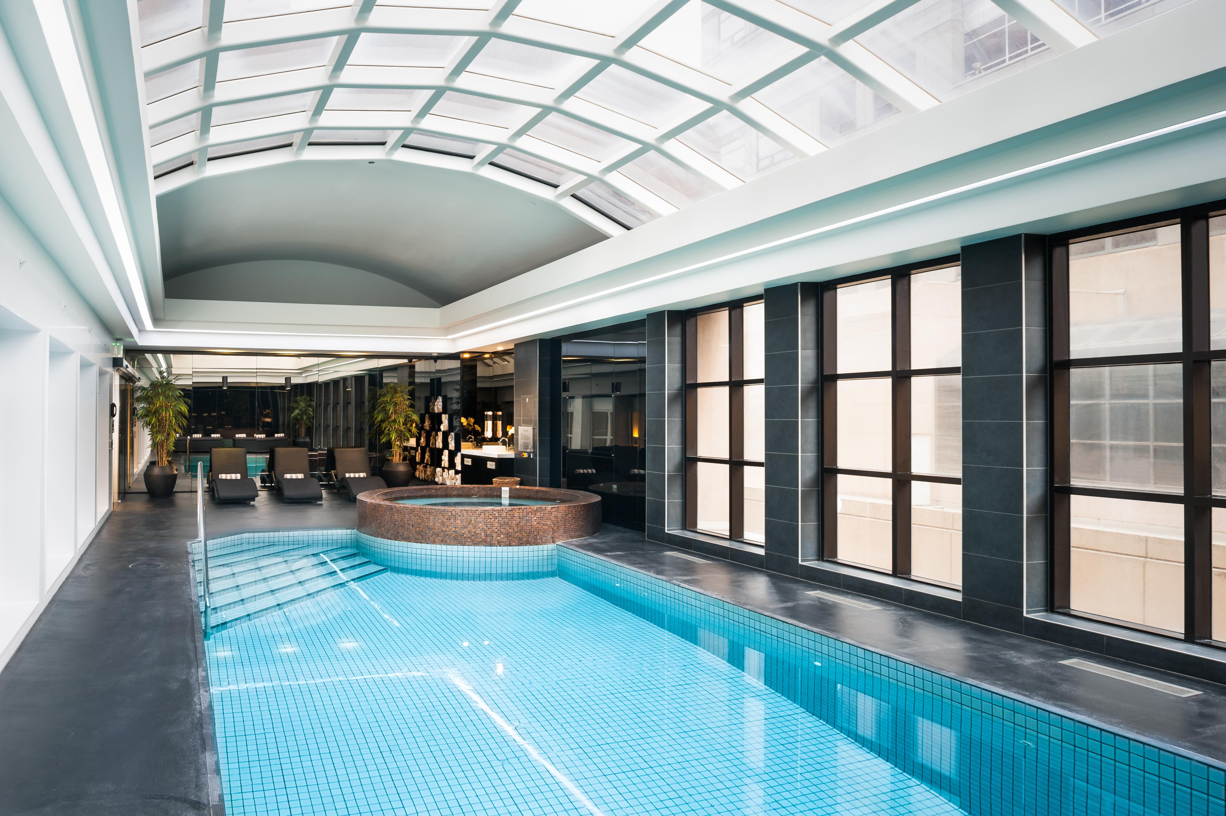 Hotel Stamford Plaza Melbourne Esterno foto The photo shows an indoor swimming pool area with a modern and sleek design. The pool is rectangular and features bright blue tiles. Above the pool, there's a large, transparent glass ceiling that allows natural light to flood the space. Surrounding 