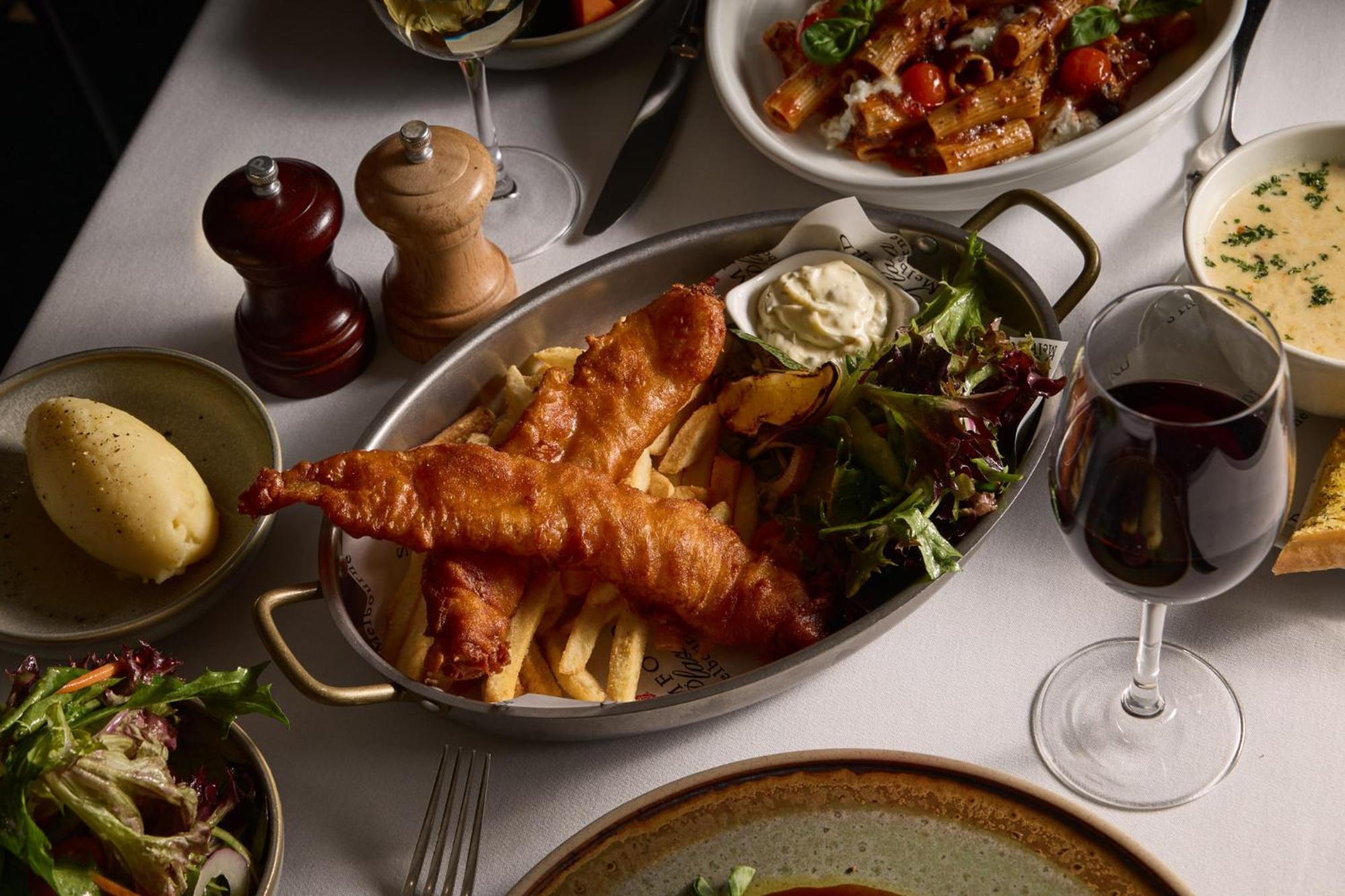 Hotel Stamford Plaza Melbourne Esterno foto The photo showcases a beautifully arranged meal. In the foreground, there are two pieces of golden-battered fish served with crispy fries. Accompanying the fish is a small dollop of creamy sauce and a side salad, which has a mix of greens. Surroundin